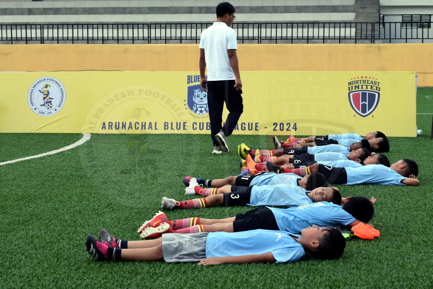 Coach overseeing young players during a group session